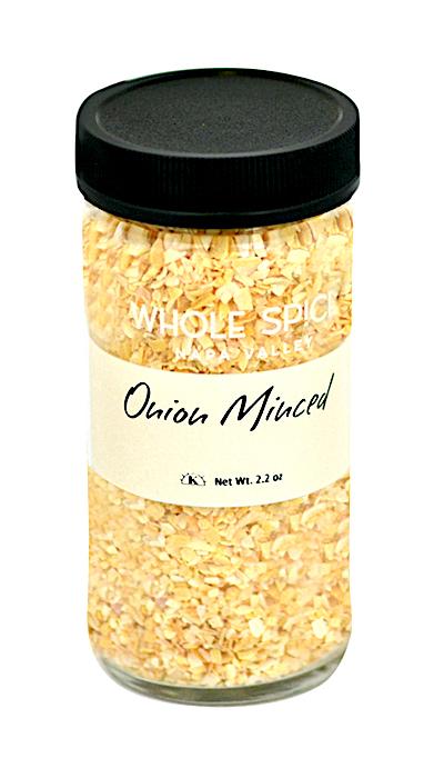 A clear glass jar with a black lid holds dehydrated minced onion. The cream label reads "Whole Spice Inc. Onion Minced" and "Net Wt. 2.2 oz" in black—a must-have culinary ingredient for your kitchen.