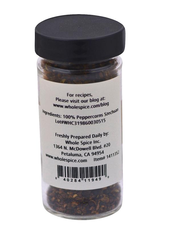 A clear spice jar with a black lid holds Peppercorns Szechuan by Whole Spice Inc., a bold seasoning for poultry. The label features ingredients, company contact info, and a website for recipes.