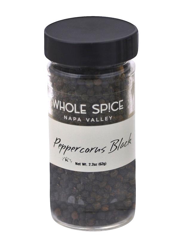 A clear spice jar with a black lid from Whole Spice Inc., labeled Peppercorns Black, contains whole pepper. The label lists the net weight as 2.2 oz (62g).