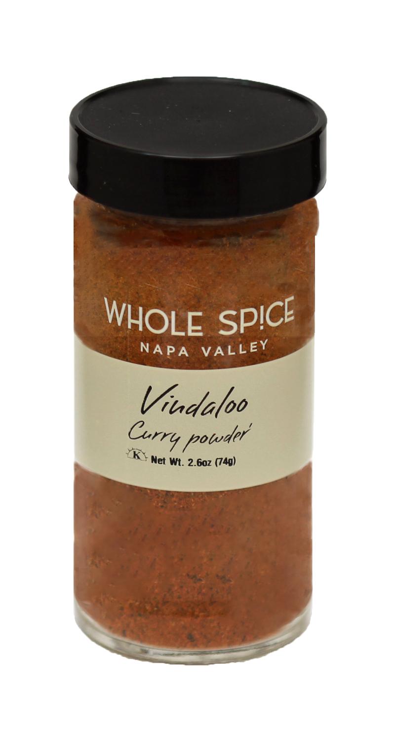 A 2.6 oz (74g) glass jar of Whole Spice Inc. Vindaloo Curry Powder with a black lid, featuring reddish-brown curry powder inspired by Goan cuisine.