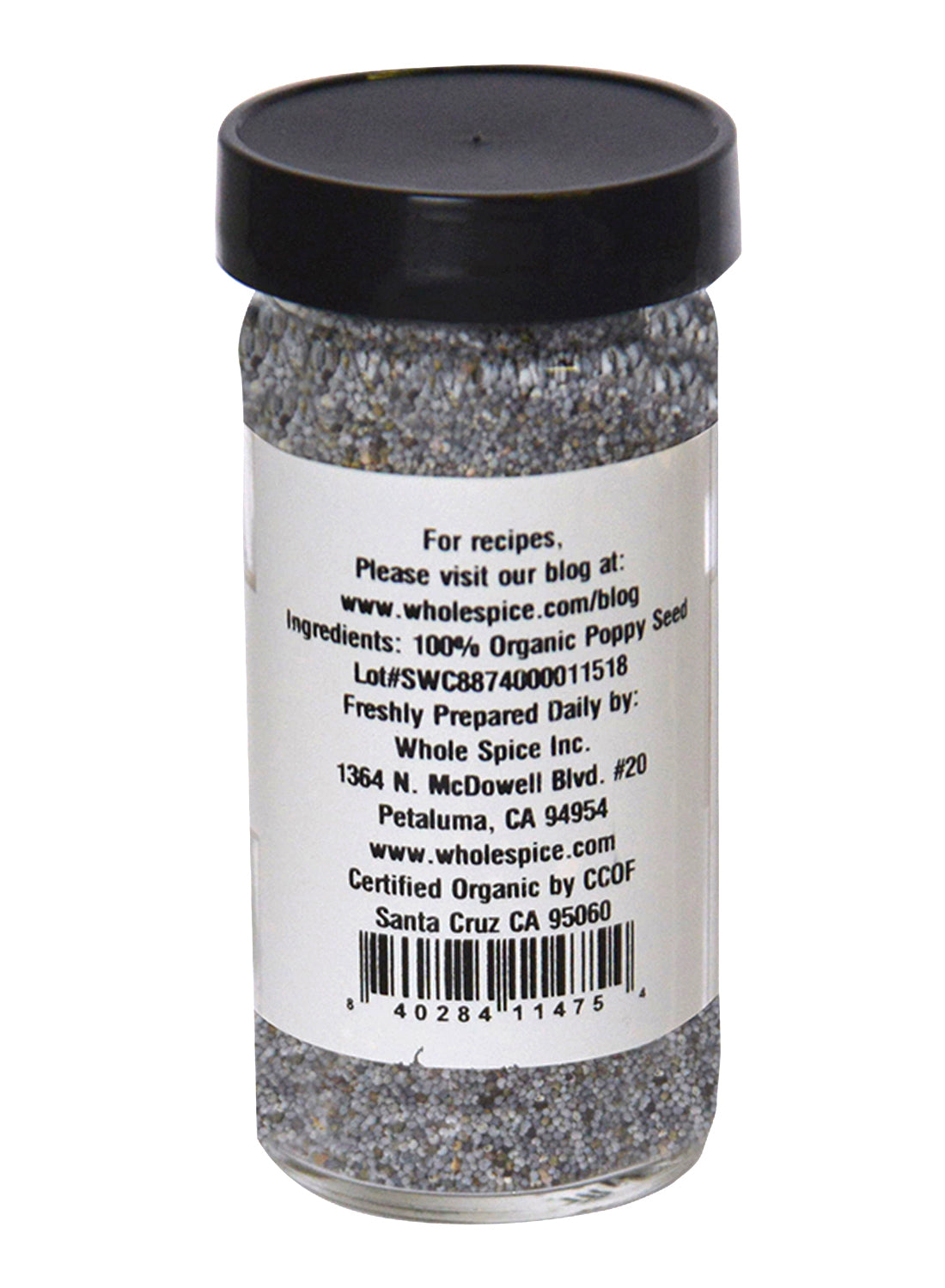 A clear glass jar with a black lid contains Poppy Seeds Organic by Whole Spice Inc.—perfect for sauces or pastry fillings. The white label lists ingredients, company info, website, barcode, 100% Organic Poppy Seed, and contact details.