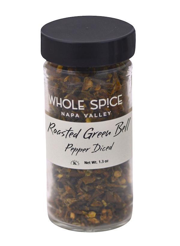 A clear glass jar with a black lid labeled Whole Spice Inc. Roasted Green Bell Pepper Diced contains diced dehydrated green bell peppers. Net weight: 1.3 oz.