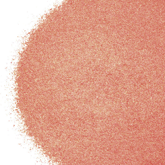 A close-up of Whole Spice Inc.’s Rosebud Powder—a fine, pinkish-orange powder for baking—spread on a white background, densely packed on one side and scattered sparsely at the edges.