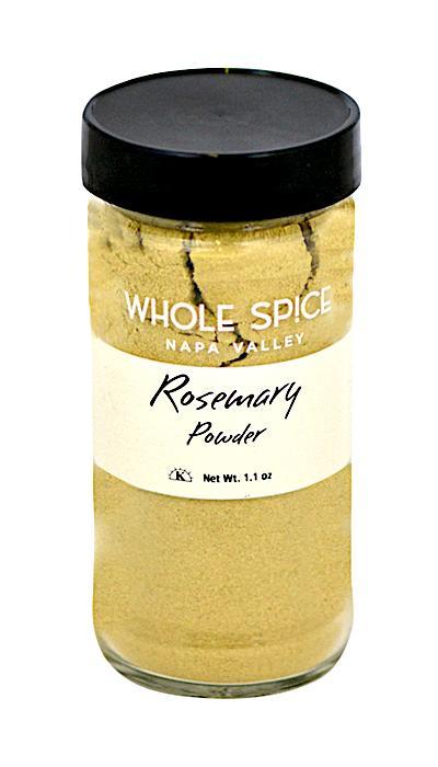 A clear glass jar with a black lid holds finely ground rosemary powder. The label reads "Rosemary Powder" by Whole Spice Inc., Net Wt. 1.1 oz.