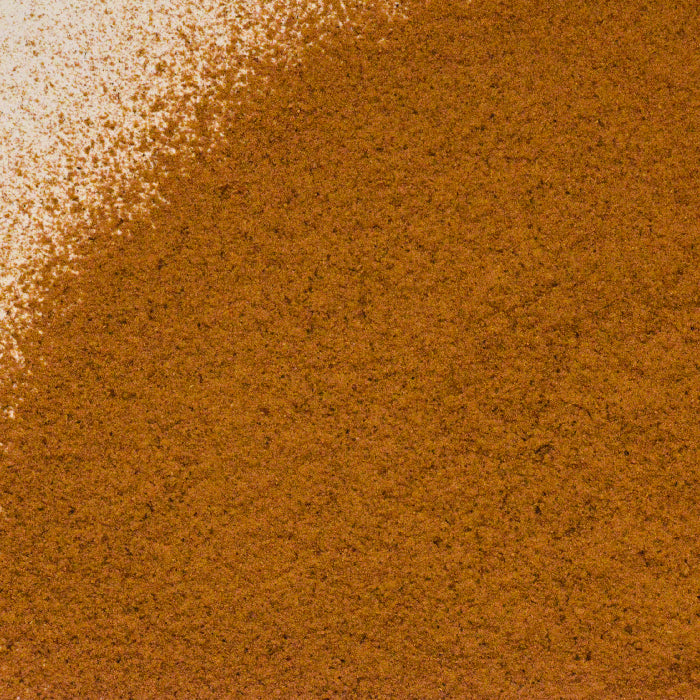 Close-up of Whole Spice Inc. Sarsaparilla Root Powder, showing its fine brown texture with a lighter patch in the upper left corner for a natural gradient effect.
