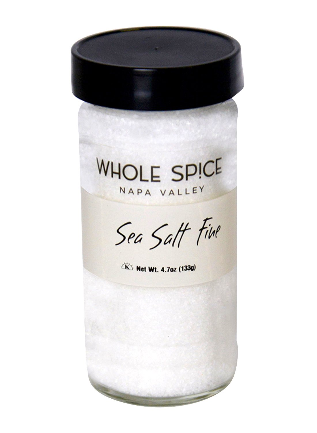 A clear glass jar with a black lid, labeled Whole Spice Inc. Sea Salt Fine, contains 4.7 ounces (133g) of pure sea salt.