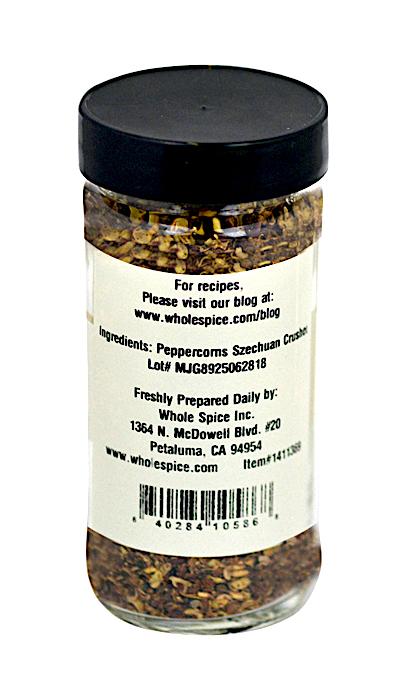 Pepper Szechuan Crushed by Whole Spice Inc. comes in a clear jar with a black lid, labeled with ingredients, prep location, contact details, and a barcode at the bottom—an essential Chinese seasoning for meat and poultry.