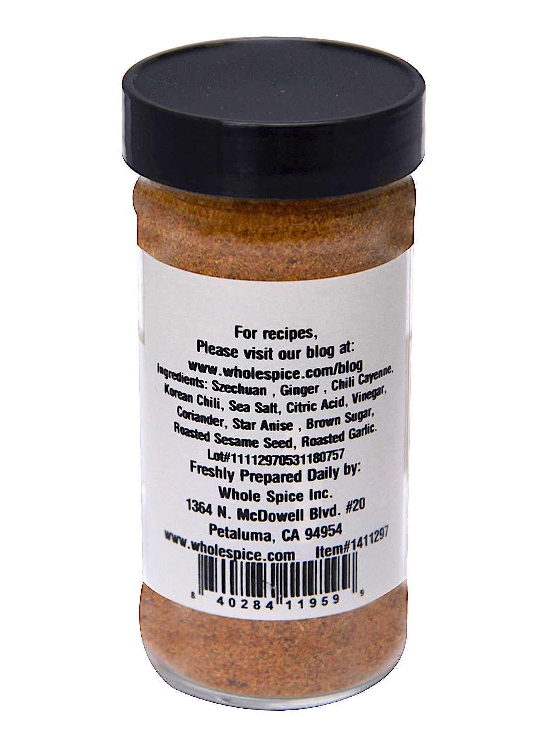 A rear view of the Szechuan Seasoning jar by Whole Spice Inc., showing a label with ingredients—ginger, Szechuan peppercorns, coriander, Korean chili flakes—plus contact info, a barcode, website, and address.
