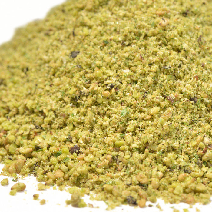 A close-up of ground pistachios, showcasing green and brown nut pieces—ideal for adding texture to your homemade tahini or blending with Whole Spice Inc. Tahini Dry Mix.