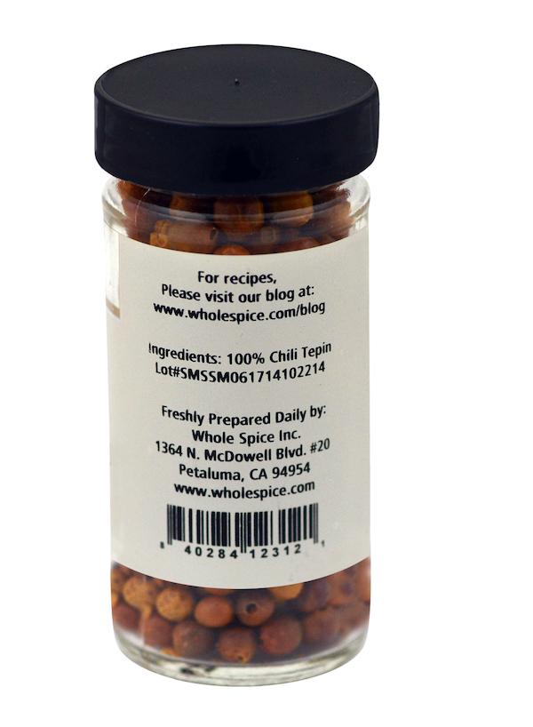 Whole Spice Inc.'s Tepin Chili Whole comes in a clear jar with a black lid, labeled “100% Chili Tepin,” plus recipe website and contact info—ideal for those who crave bold, spicy pepper flavor.