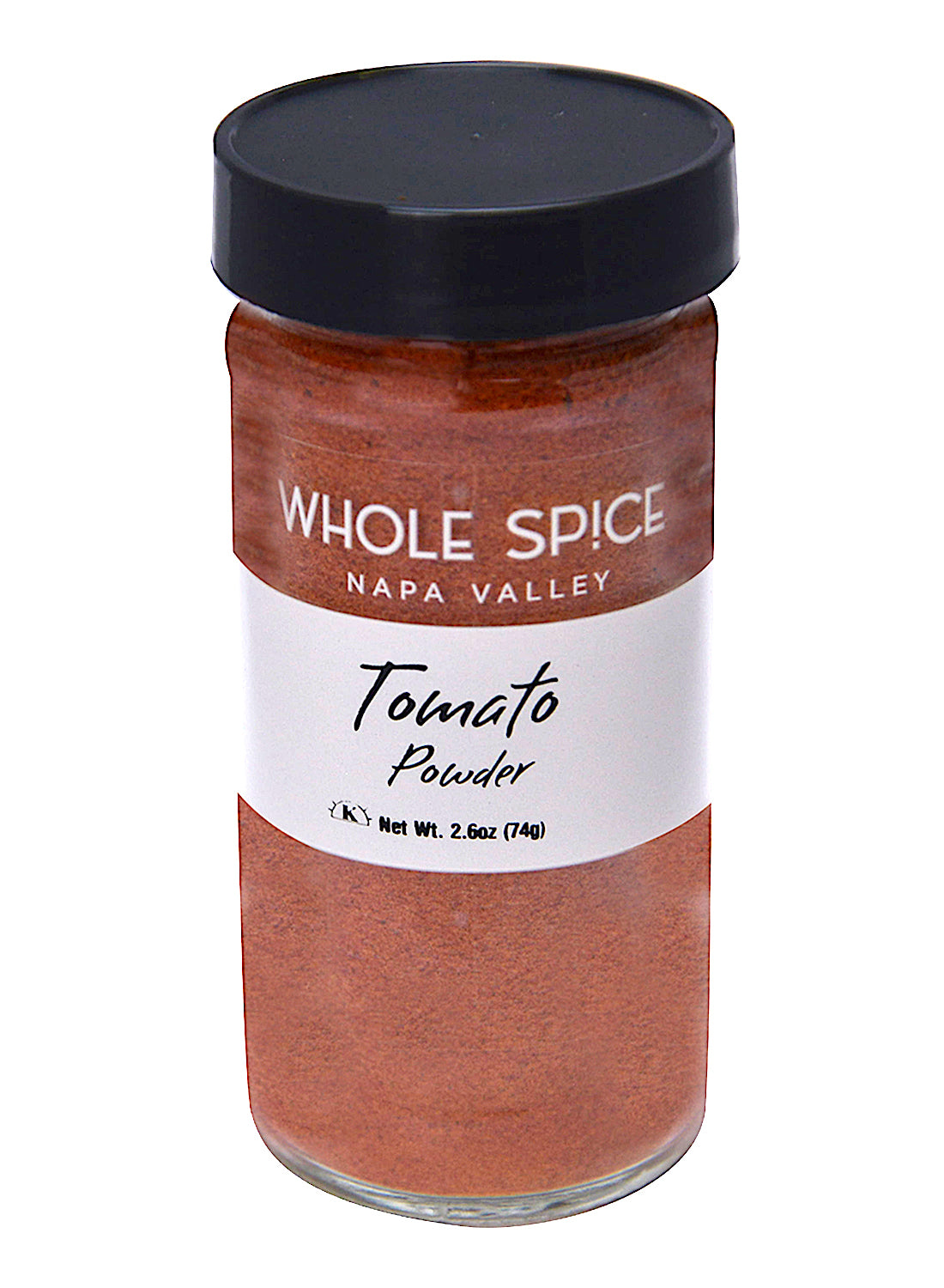 A clear glass jar with a black lid labeled "Whole Spice Inc. Tomato Powder" contains 2.6 oz (74g) of reddish-brown dehydrated tomato powder, ideal as a soup base.