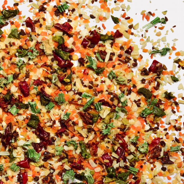 Whole Spice Inc. Vegetable Flakes feature a blend of dried carrots, green herbs, red peppers, and onion pieces—perfect for adding vibrant color and flavor to soups or salad dressings.