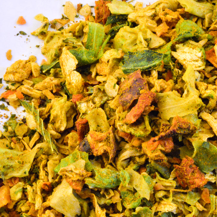 A close-up of Veggie Couscous Seasoning by Whole Spice Inc., a vibrant dried mix with green, orange, and yellow vegetables—ideal for couscous or blending into your favorite herbs and spices.