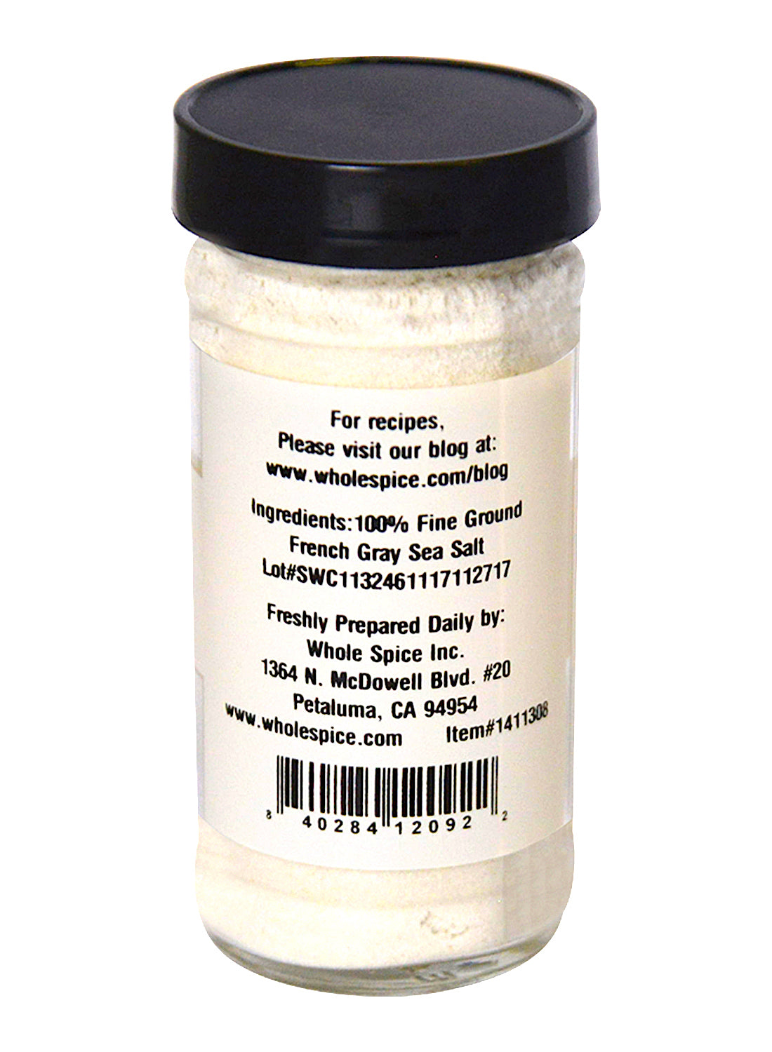 A clear glass jar with a black lid contains Whole Spice Inc.'s Velvet de Guerande Sea Salt, fine ground French Gray and unrefined. Its label includes ingredients, manufacturer info, website, and contact details. Perfect as a finishing salt.