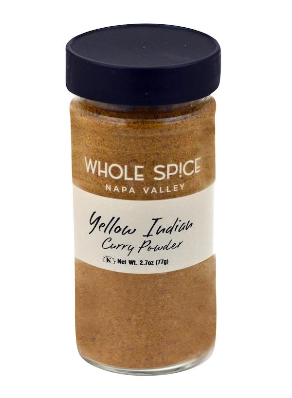A 2.7 oz (77g) glass jar with a black lid containing freshly ground Yellow Indian Curry Powder from Whole Spice Inc.