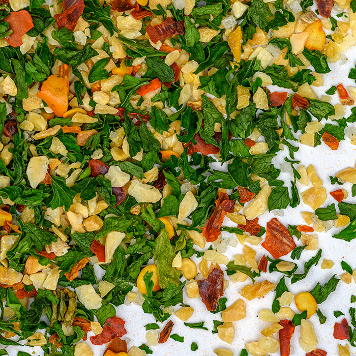 A close-up of Whole Spice Inc.'s Aglio Olio E Pepperoncino dried vegetable mix, featuring colorful herbs and veggies, perfect for adding authentic Italian flavor to any dish.