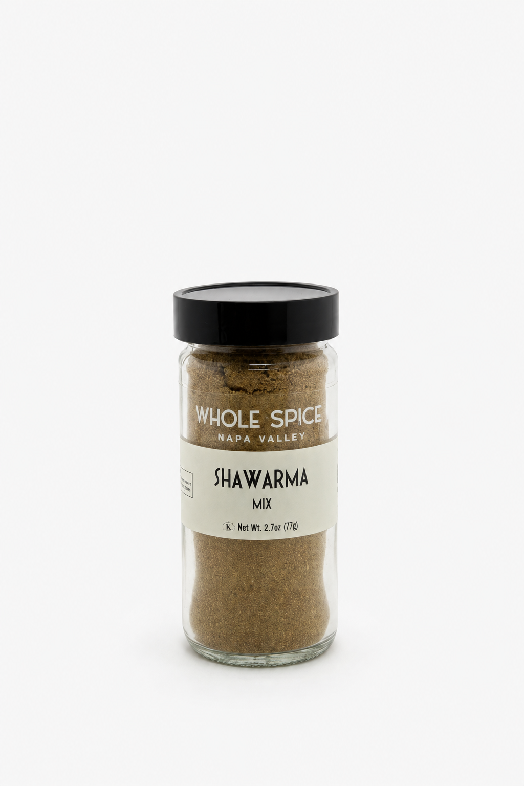 A glass jar with a black lid, labeled Whole Spice Inc. Shawarma Spice Mix, containing a finely ground brownish blend of distinctive Middle Eastern spices, displayed against a plain white background.