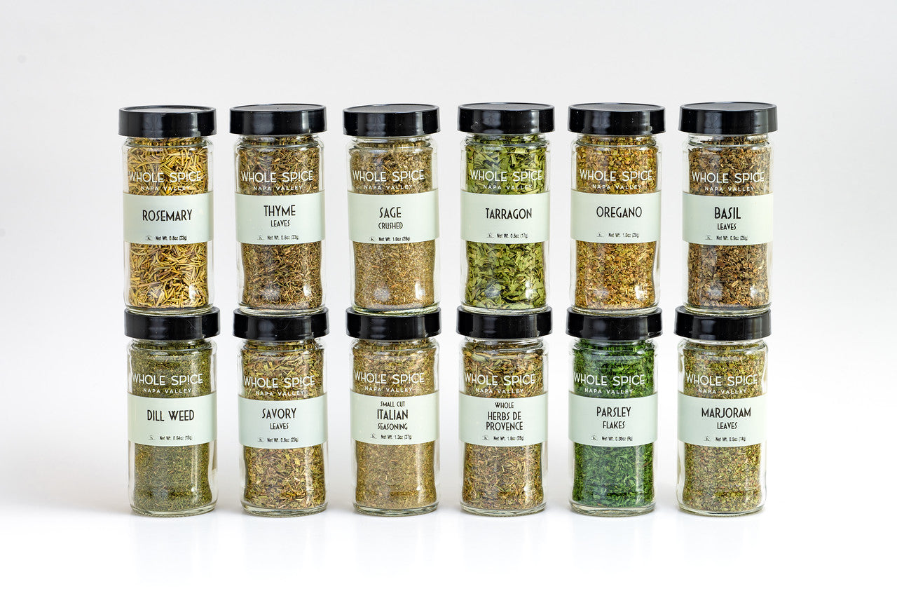 The Whole Spice Herbs Jar Set by Whole Spice Inc. includes 12 dried herbs like rosemary, thyme, basil, and oregano—ideal for elevating any recipe. Each whole spice jar is arranged neatly in two rows on a white background.