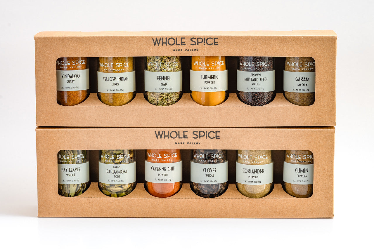 Two cardboard boxes with clear windows display the Whole Spice Inc. Indian Jar Set, featuring assorted spices like fenugreek, turmeric, fennel, mustard seed, bay leaves, cardamom, cayenne chili, coriander, and cumin.