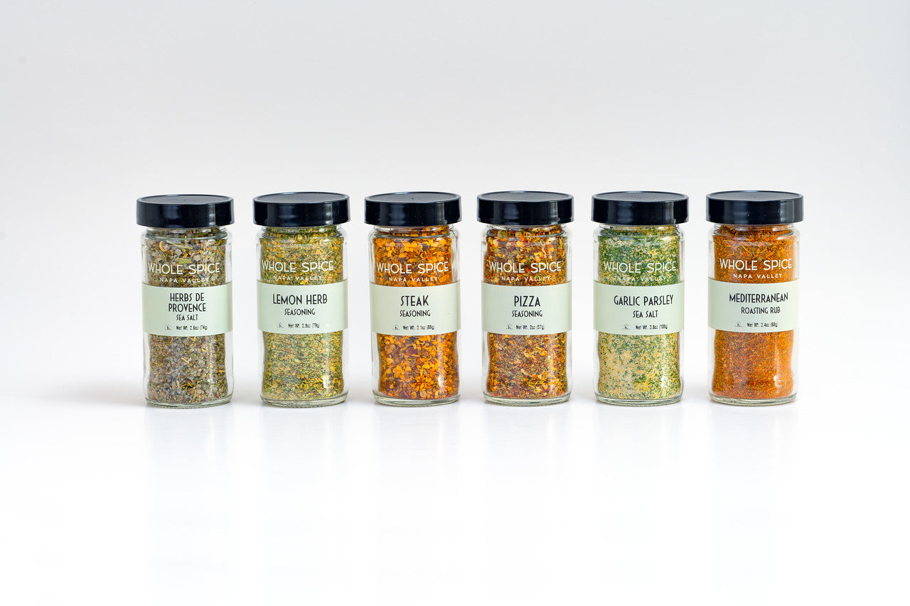 The Whole Spice Mother's Day Roasting Spice Set by Whole Spice Inc. features six jars in unique flavors: Herbes de Provence, Lemon Herb, Steak, Pizza, Garlic Parsley, and Mediterranean, all arranged on a white background.