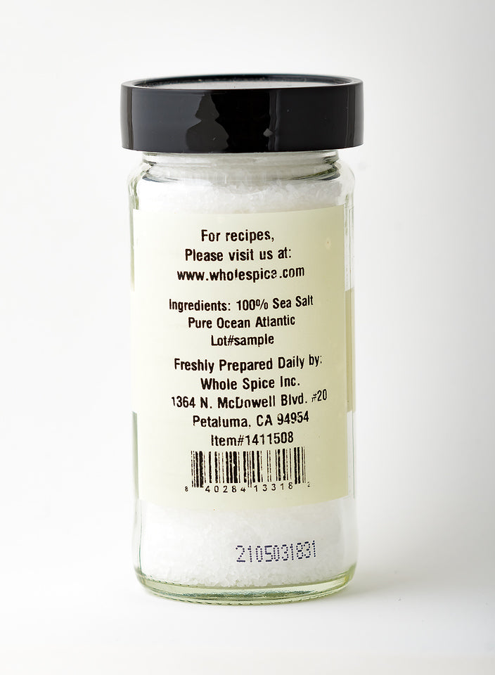 A clear glass jar of Whole Spice Inc. Pretzel Sea Salt with a back label listing ingredients as 100% Atlantic Ocean sea salt, plus company and contact info.