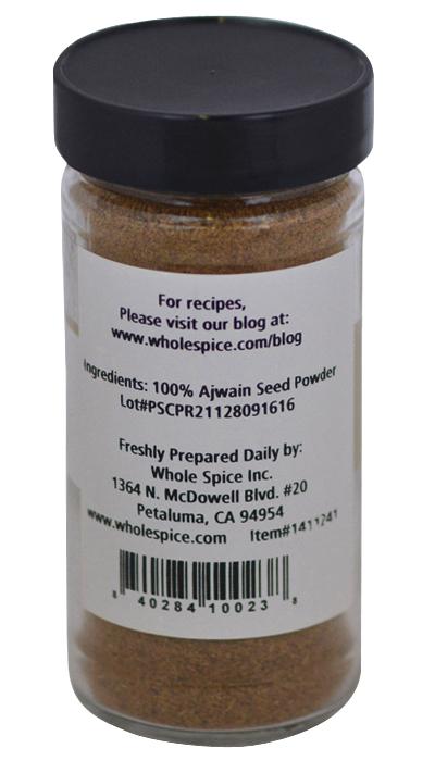 A clear spice jar with a black lid labeled "Ajwain Seed Powder" from Whole Spice Inc. Perfect for Indian dishes, the label features the brand name, address, and a barcode at the bottom.