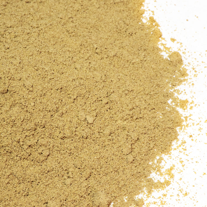 A close-up of Whole Spice Inc.'s Anise Powder, a light brown, finely ground blend, spread over a white surface—densely packed on the left and gradually scattered to the right.