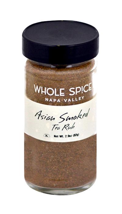 A clear glass jar of Whole Spice Inc. Asian Smoked Tea Rub with a black lid and white label shows the brown blend inside, featuring Lapsang Souchong Tea for bold flavor. Net weight: 2.9 oz (82g).