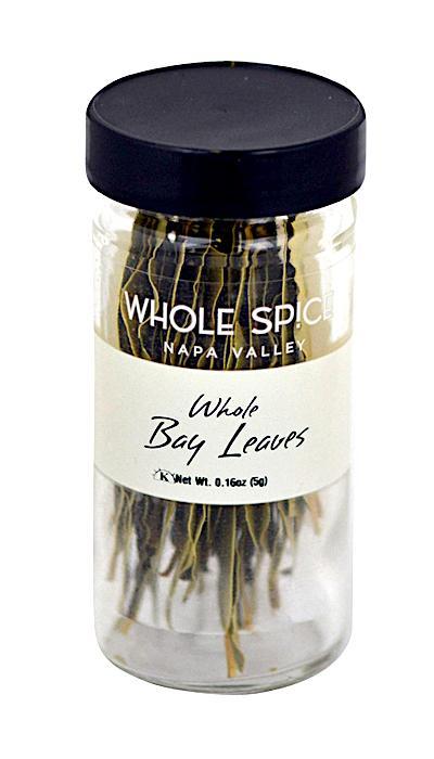A clear jar with a black lid labeled Whole Spice Inc. Bay Leaves Whole contains dried Laurus nobilis leaves, essential for cooking. The net weight on the label is 0.16 oz (5g).