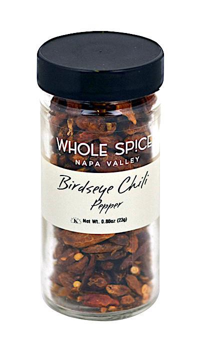 A glass jar labeled Whole Spice Inc. Bird's Eye Chili Whole with a black lid, filled with dried bird's eye chili peppers. Net weight: 0.8 oz (23g).