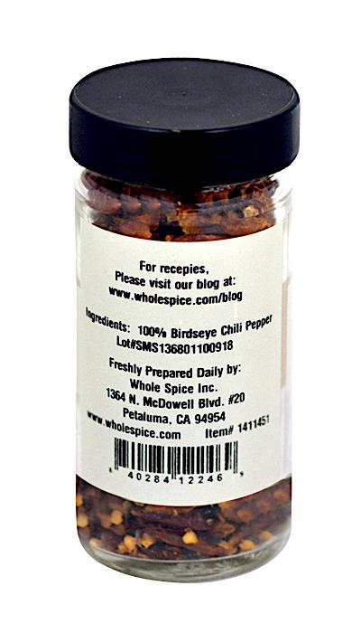 A clear spice jar from Whole Spice Inc. with a black lid contains Bird’s Eye Chili Whole, labeled as 100% Bird's eye chili, plus preparation tips and a website link for Peri peri recipes.
