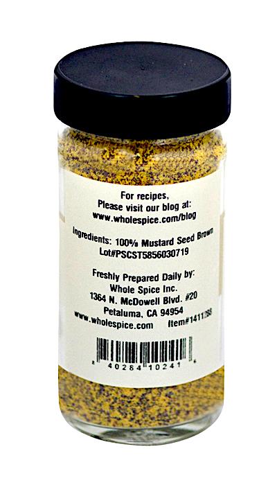 Brown Mustard Seed Ground by Whole Spice Inc. is a clear jar with a black lid, filled with yellow-brown mustard seed powder (100% Brassica nigra). Label includes manufacturer’s address and barcode. Ideal for Dijon mustard recipes.