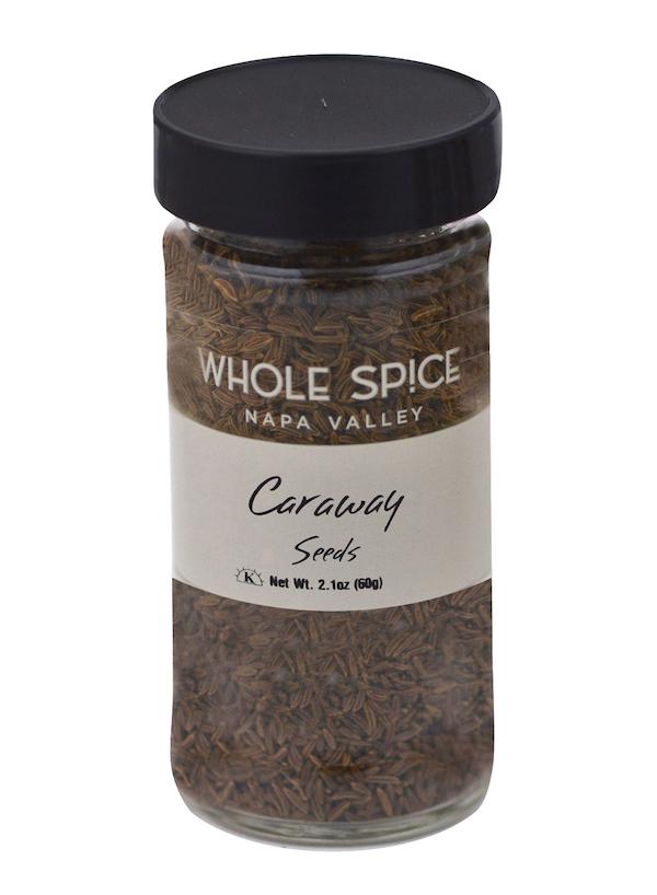 A clear glass jar with a black lid holds caraway seeds from Whole Spice Inc.—ideal for flavoring rye breads. The label says Caraway Seeds, Net Wt. 2.1oz (60g).