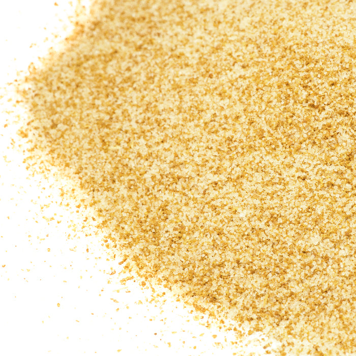 A pile of Whole Spice Inc. Celery Salt, resembling seasoning, rests on a white surface.