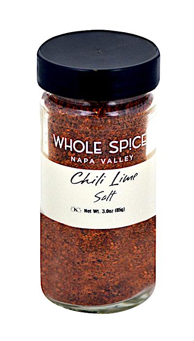 A clear glass jar with a black lid labeled Whole Spice Inc. Chili Lime Salt holds reddish-brown seasoning, ideal as margarita rim salt or to add zesty flavor to your dishes.