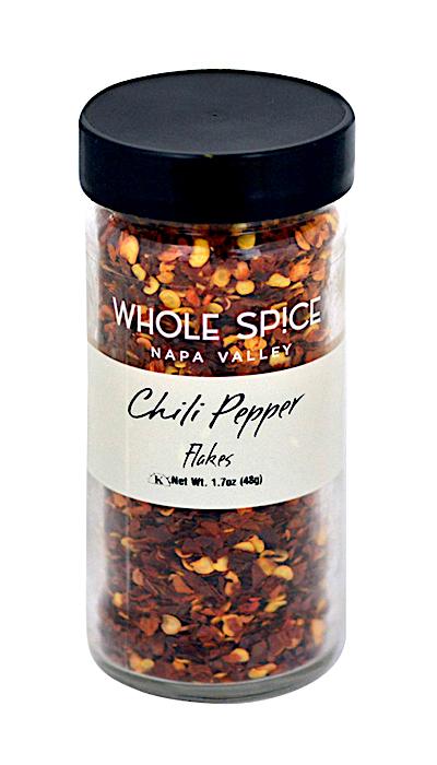 A clear glass jar with a black lid contains Chili Pepper Flakes by Whole Spice Inc., labeled "Chili Pepper Flakes Net Wt. 1.7oz (48g).