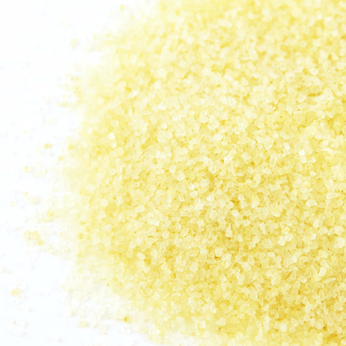 Chili Verde Sea Salt by Whole Spice Inc. forms a sparkling pile of yellow crystals, reminiscent of spicy salt.