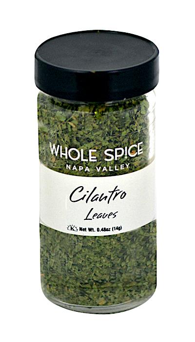 Whole Spice Inc. Cilantro Leaves come in a clear glass jar with a black lid, holding 0.48 oz (14g) of dried cilantro—a versatile herb ideal for enhancing spicy dishes.