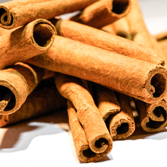 A close-up of Whole Spice Inc. Cinnamon Sticks Organic, showing their textured, rolled surfaces and warm brown color. Natural lighting highlights the rich details of these high-quality organic sticks.