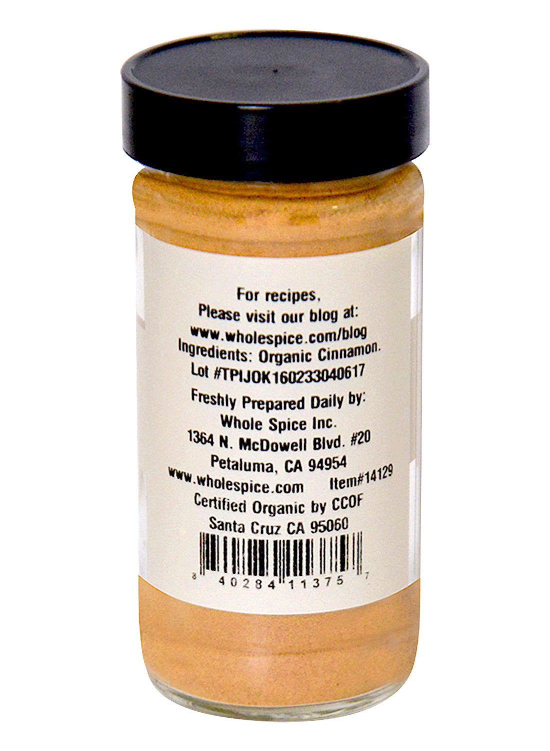 Cinnamon Powder Organic by Whole Spice Inc. comes in a glass jar with a black lid, featuring label details like ingredients, company info, certifications, website, and a barcode. The jar contains light brown organic cinnamon powder ideal for Indian cuisine.