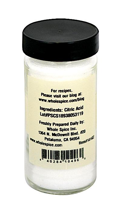 A clear jar with a black lid holds white citric acid powder (sour salt) from Whole Spice Inc., perfect for sausage making. The label lists the brand’s contact info, website, address, and lot number.