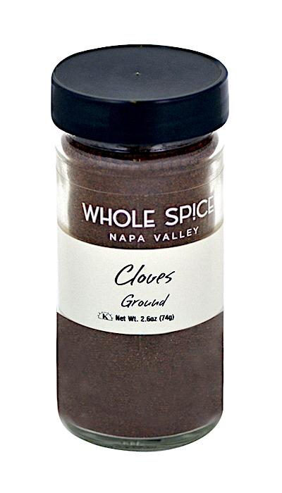 A 2.6 oz (74g) glass jar of Whole Spice Inc. Cloves Ground, ideal for baking, has a black lid and a white label featuring the product name and net weight.