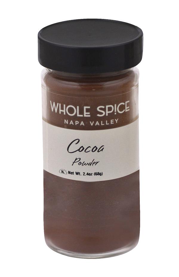 A 2.4 oz (68g) clear glass jar of Cocoa Powder by Whole Spice Inc. with a black lid—ideal for baking rich chocolate cakes or enhancing your favorite desserts.