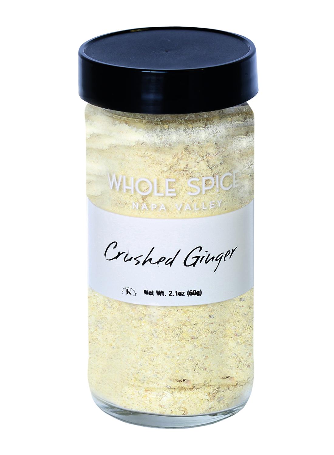 A clear glass jar with a black lid contains Whole Spice Inc. Ginger Crushed, a pale yellow aromatic powder. Net weight is 2.1 oz (60g). Ideal for adding bold ginger flavor to your favorite dishes.