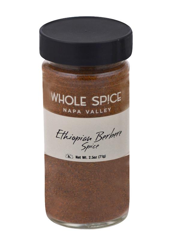 A clear glass jar with a black lid contains Ethiopian Berbere Spice by Whole Spice Inc.—a reddish-brown blend perfect for spicy food lovers and Ethiopian lentil stews. Net Wt. 2.5oz (71g).