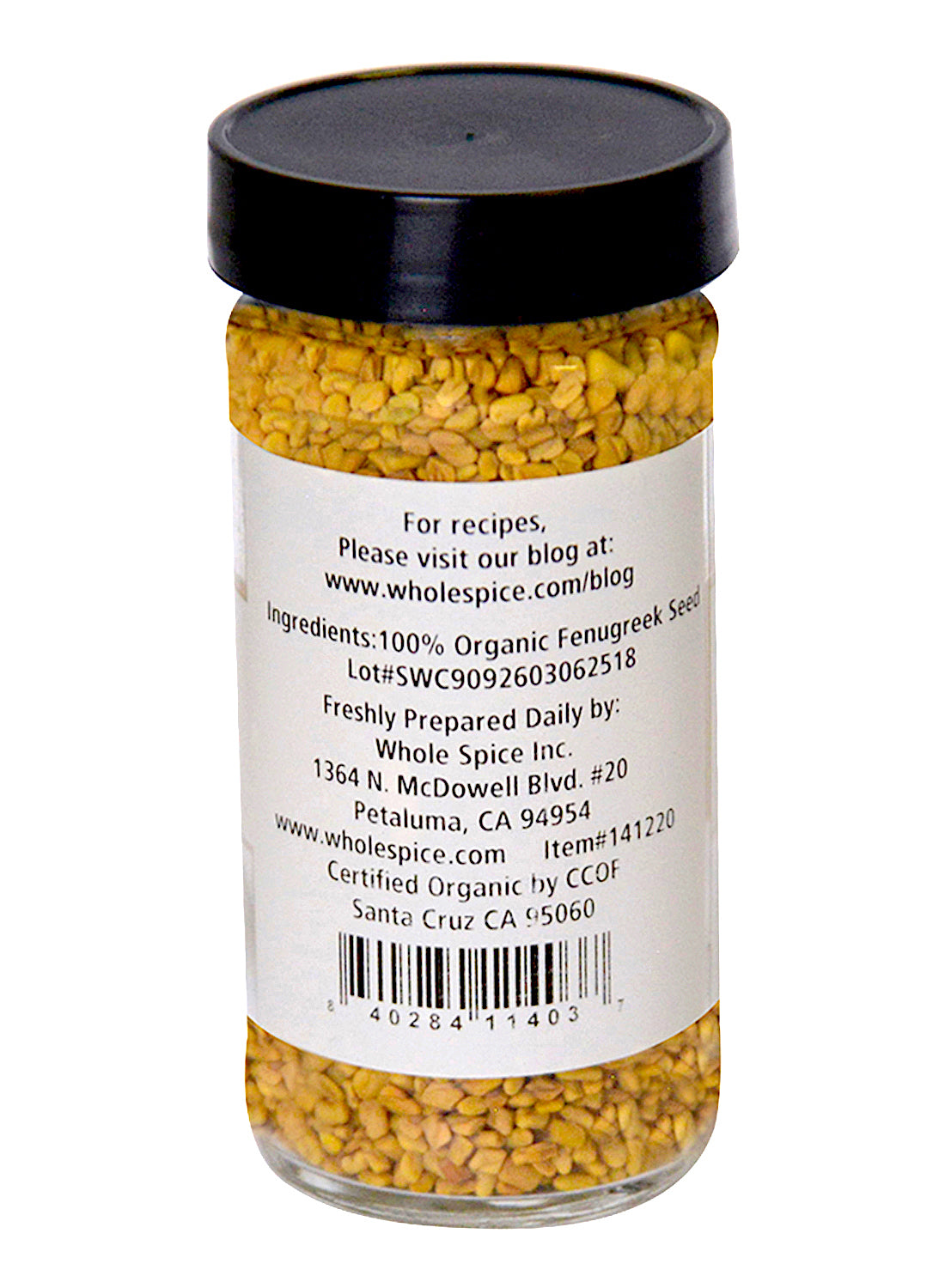 A clear glass jar with a black lid holds yellow Fenugreek Seeds Organic by Whole Spice Inc., labeled as 100% organic spice and featuring company and blog details.