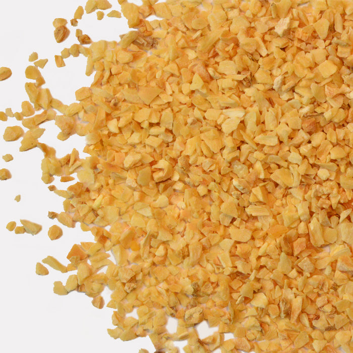 A close-up of Organic Onion Minced by Whole Spice Inc., showing finely chopped pieces scattered on a white background.