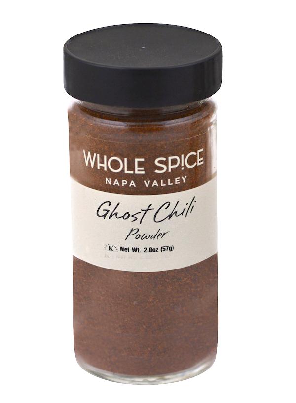 A jar of Ghost Chili Powder by Whole Spice Inc., featuring a black lid and made from the fiery Bhut Jolokia, one of the world’s hottest peppers.