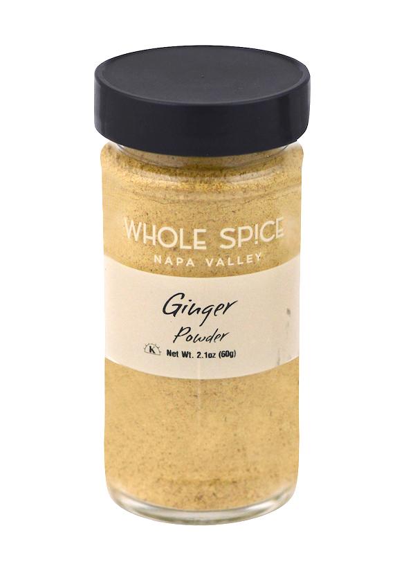 A clear glass jar with a black lid holds aromatic Ginger Powder by Whole Spice Inc., labeled "Ginger Powder, Net Wt. 2.1oz (60g)," a versatile spice for your kitchen.