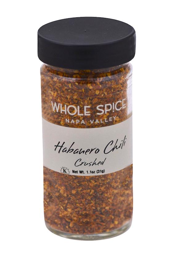 A glass jar of Whole Spice Inc. Habanero Chili Crushed features hot chili pepper flakes with high Scoville heat units, a black lid, and contains 1.1 oz (31g).